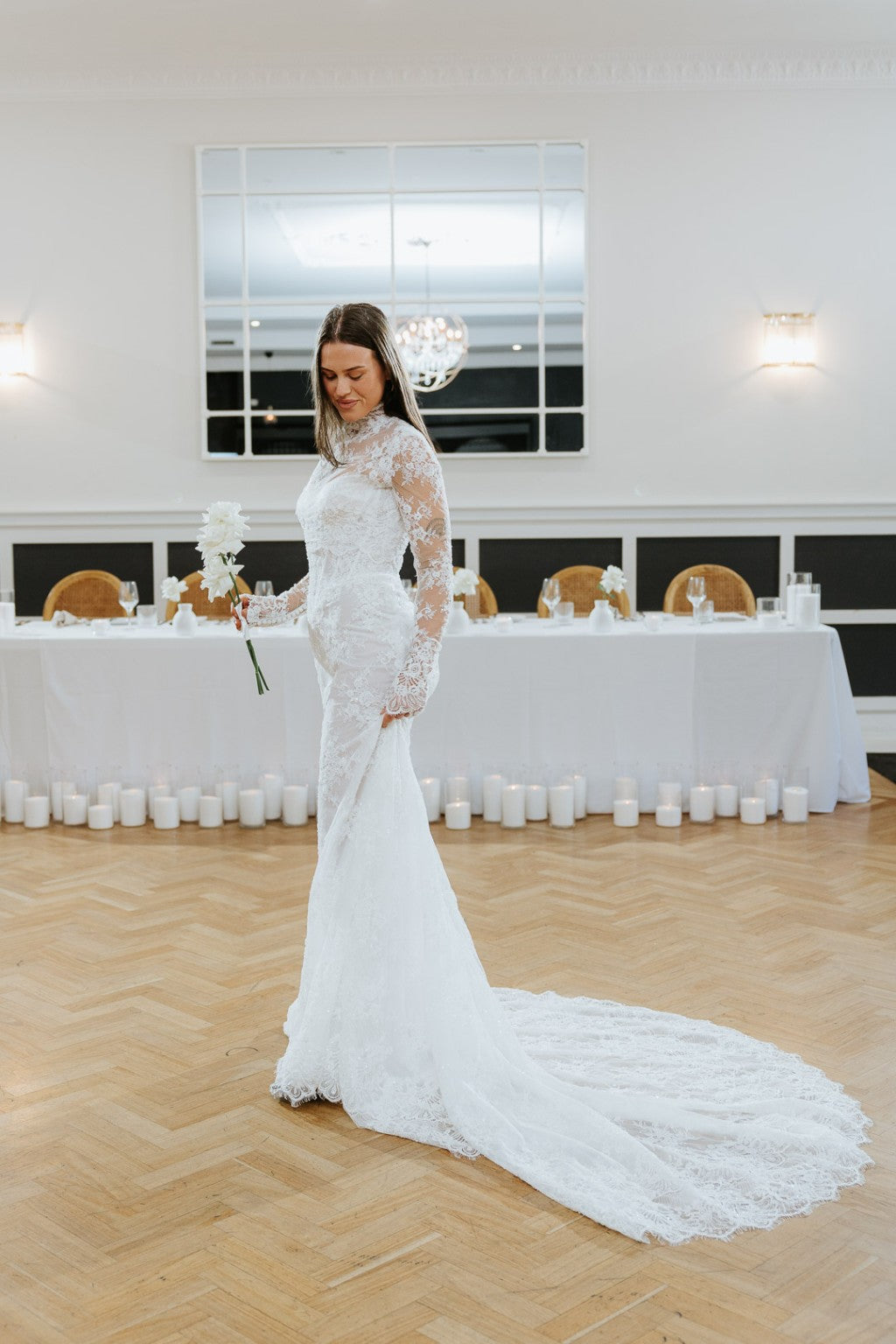 Chiara fitted French lace wedding gown side profile with sweeping lace train at wedding venue